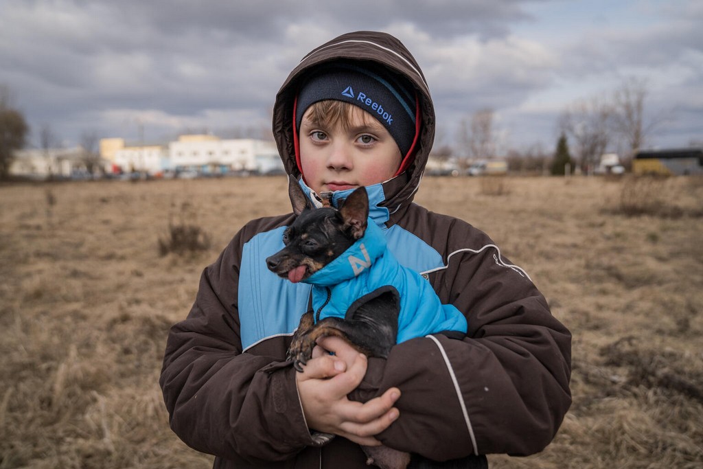 Alexander, 7 years old, together with his mother Tania, and their dog Leolea, while waiting across the Ukraine-Romania.